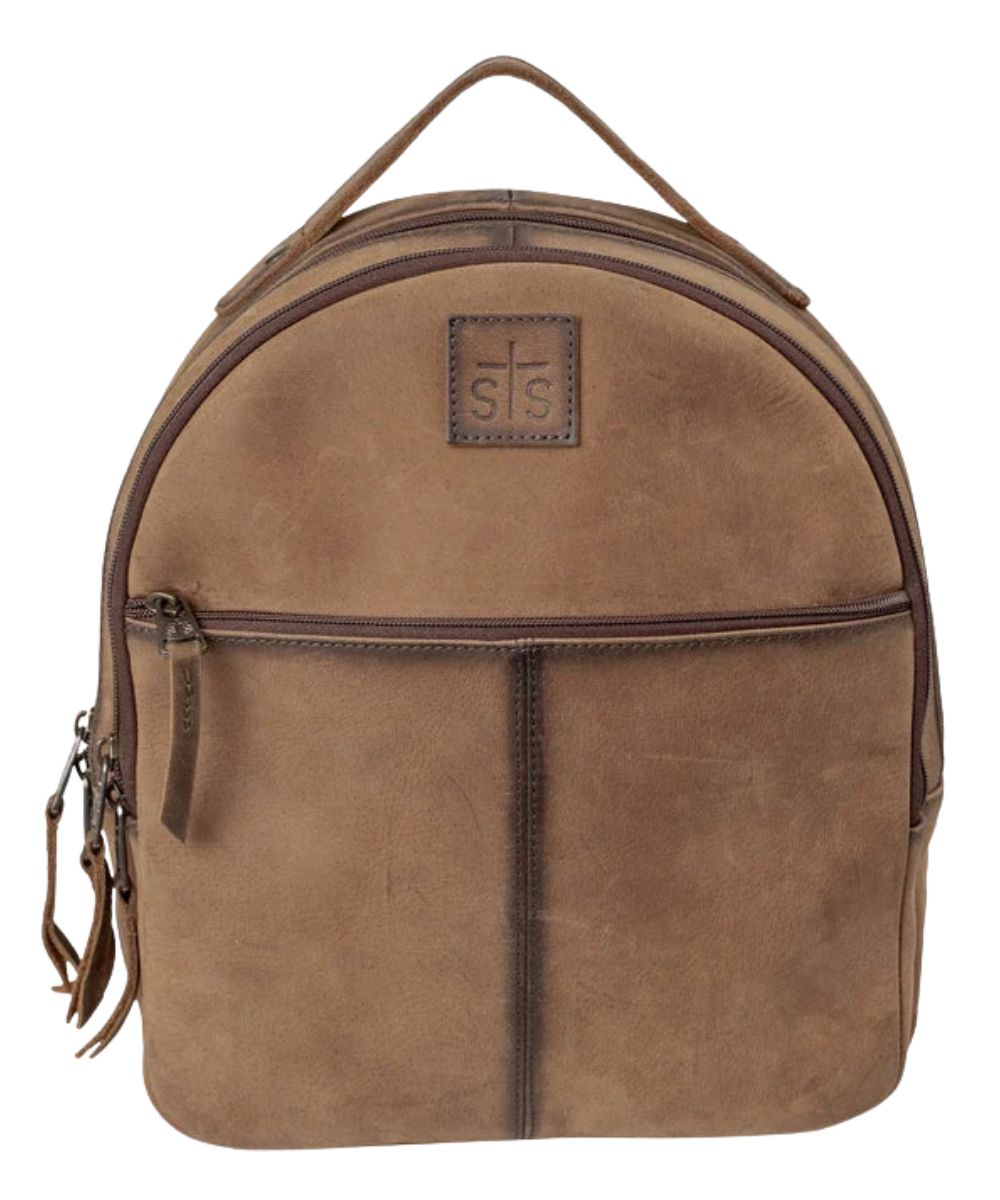Front view of the brown leather STS Baroness Phoenix Backpack featuring the front zipper pocket, top carry handle, STS logo patch, and zipper compartments