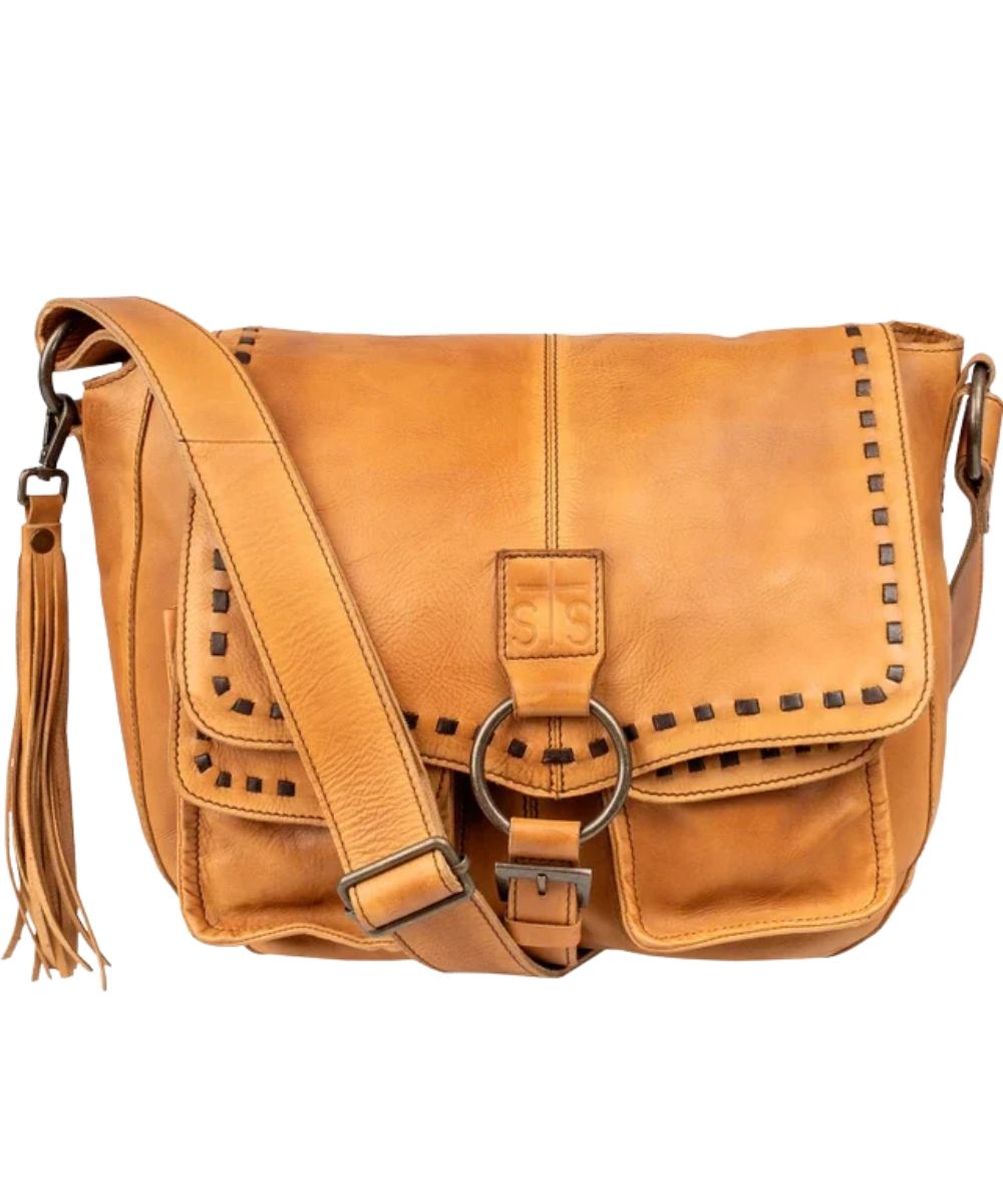 Front view of the women's tan STS Bandera Tan Saddle Hobo Bag featuring the STS stamped leather, whipstitch accents, leather shoulder strap, removable tassel, and top flap closure with slip buckle