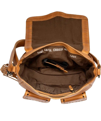Interior view of the women's tan leather hobo bag featuring the interior concealed carry pocket, 1 zipper pocket, 2 scrunch pockets, and a quote inside that reads: "Have Faith. Choose Hope. Love."