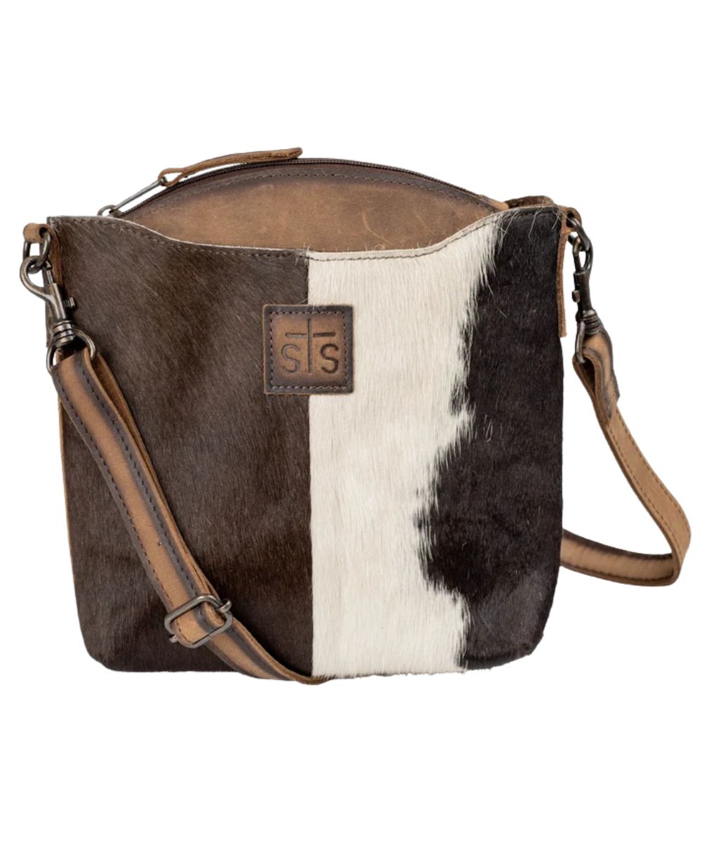 Front view of the women's brown STS Cowhide Josie Crossbody featuring the hair-on-hide leather front, front exterior pocket, STS logo patch, and an adjustable/removable leather shoulder strap