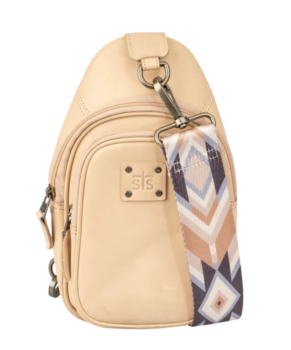 Women's beige leather sling bag shown with the removable/adjustable printed nylon shoulder strap