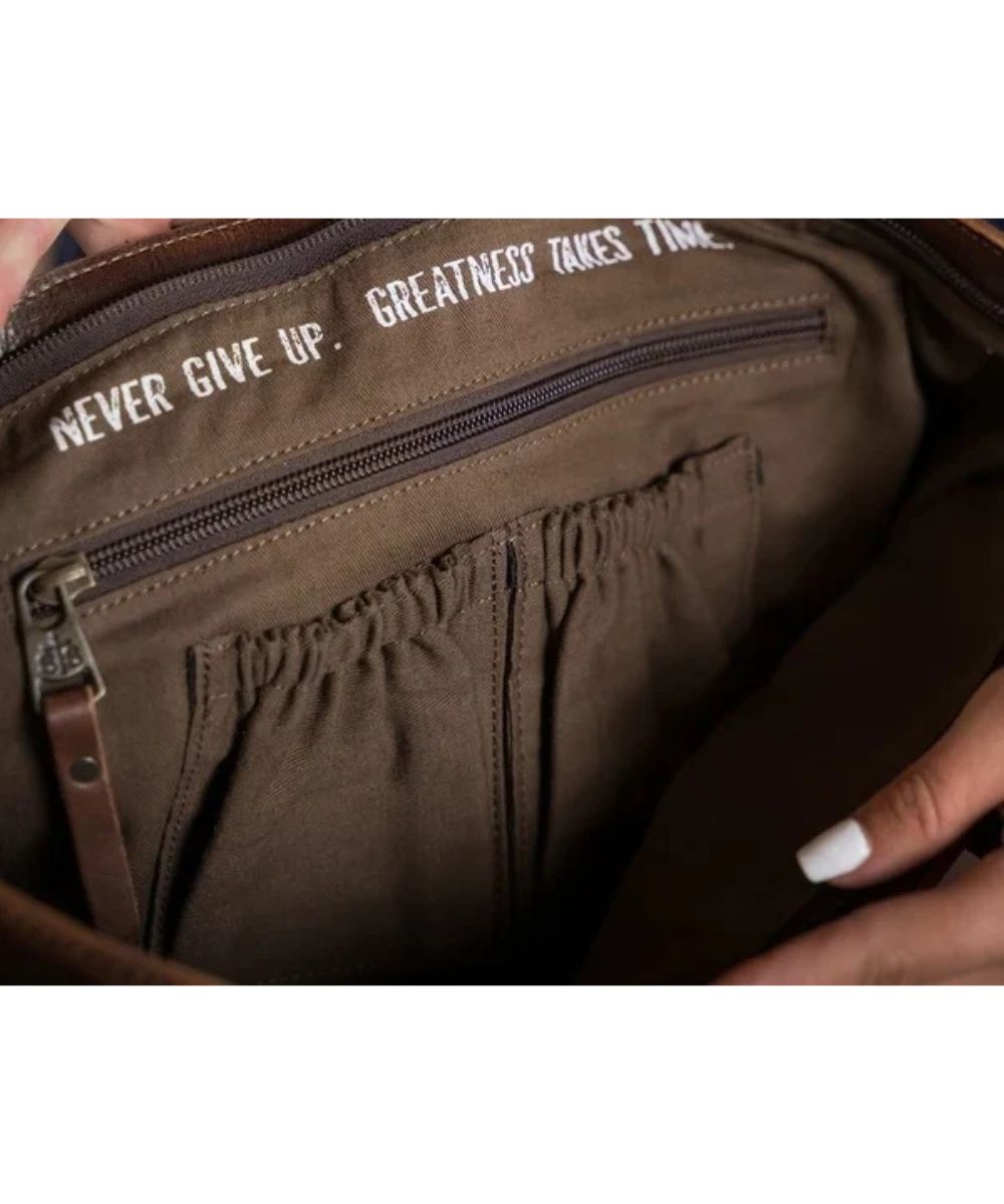 Interior view of the zipper and scrunch pockets featuring a quote that reads: "Never Give Up. Greatness Takes Time."