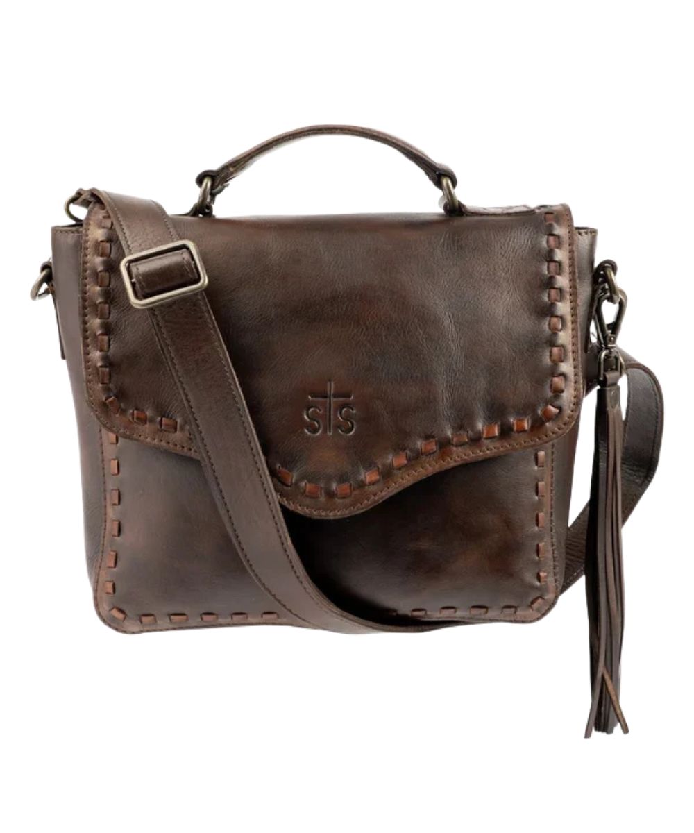 Front view of the women's STS Bandera Chocolate Dakota Crossbody Purse featuring the buckstitch trim, removable tassel, top carry handle, and magnetic flap closure
