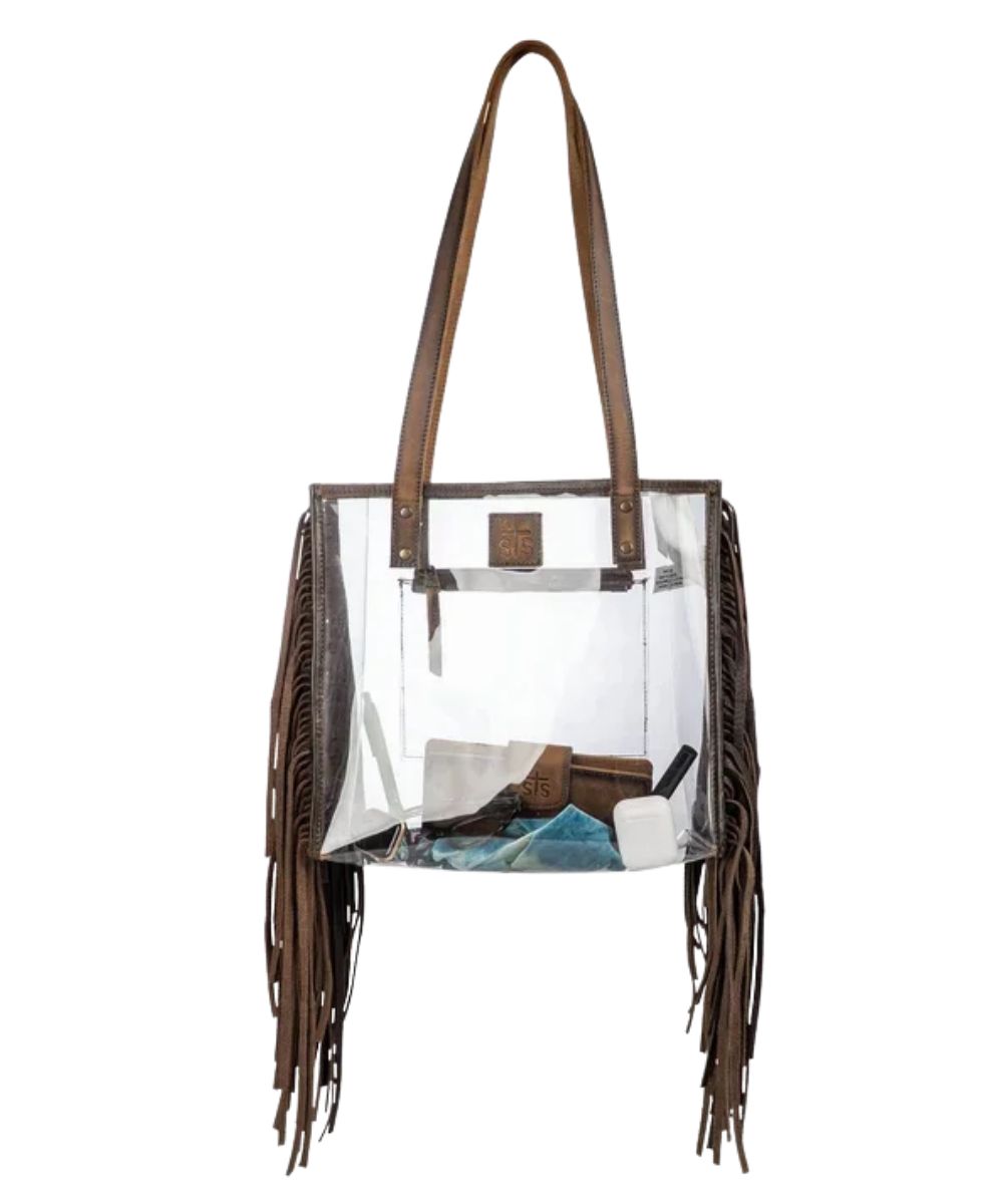 Front view of the women's clear STS Stadium Rules Fringe Tote Bag featuring the clear vinyl construction, leather fringed sides, STS logo patch, and brown leather shoulder straps