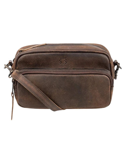 Front view of the women's brown STS Baroness Jess Crossbody featuring the STS branded leather, front zipper pocket, and an adjustable/removable leather crossbody strap