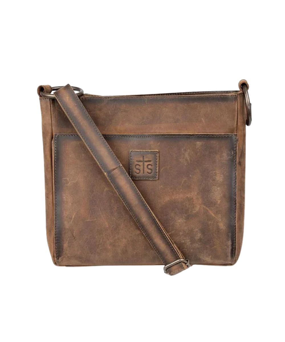 Front view of the women's brown STS Baroness Brown Olivia Crossbody featuring the genuine leather construction, STS branded leather patch, an adjustable leather crossbody strap, and a front exterior magnetic pocket 