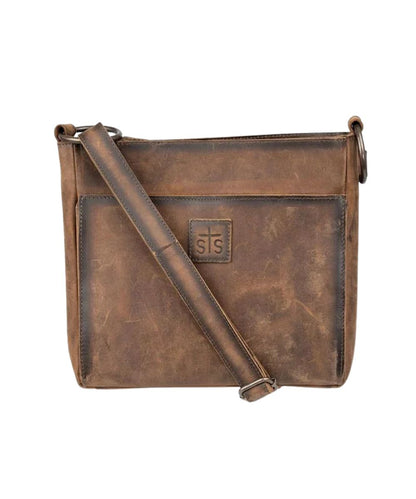 Front view of the women's brown STS Baroness Brown Olivia Crossbody featuring the genuine leather construction, STS branded leather patch, an adjustable leather crossbody strap, and a front exterior magnetic pocket 