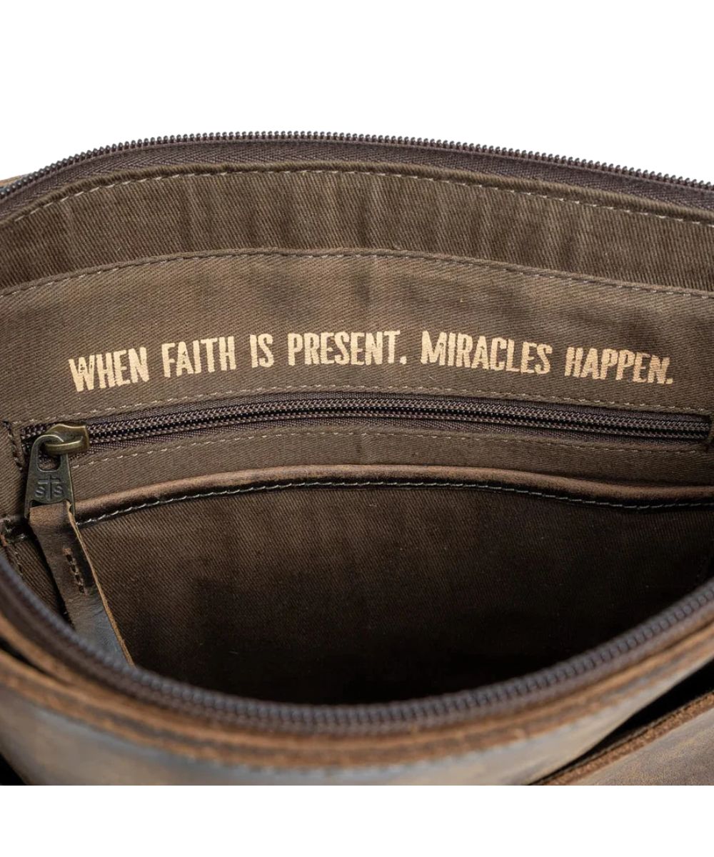 Interior view of the main compartment featuring the interior zip pocket, an open pocket, and a quote above it that reads: "When Faith Is Present, Miracles Happen."