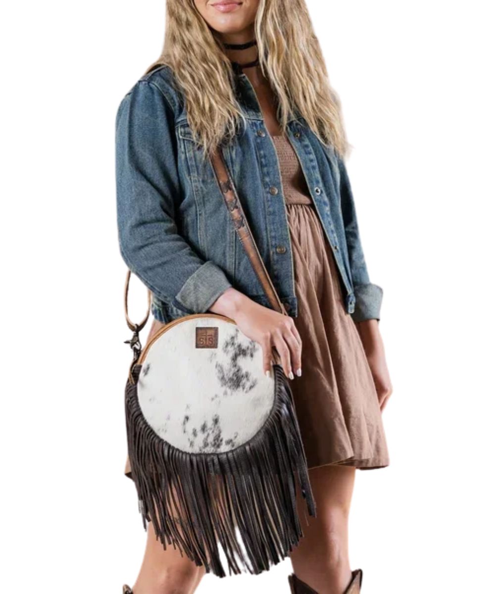 Model view of a woman modeling the cowhide circle concealed carry crossbody purse