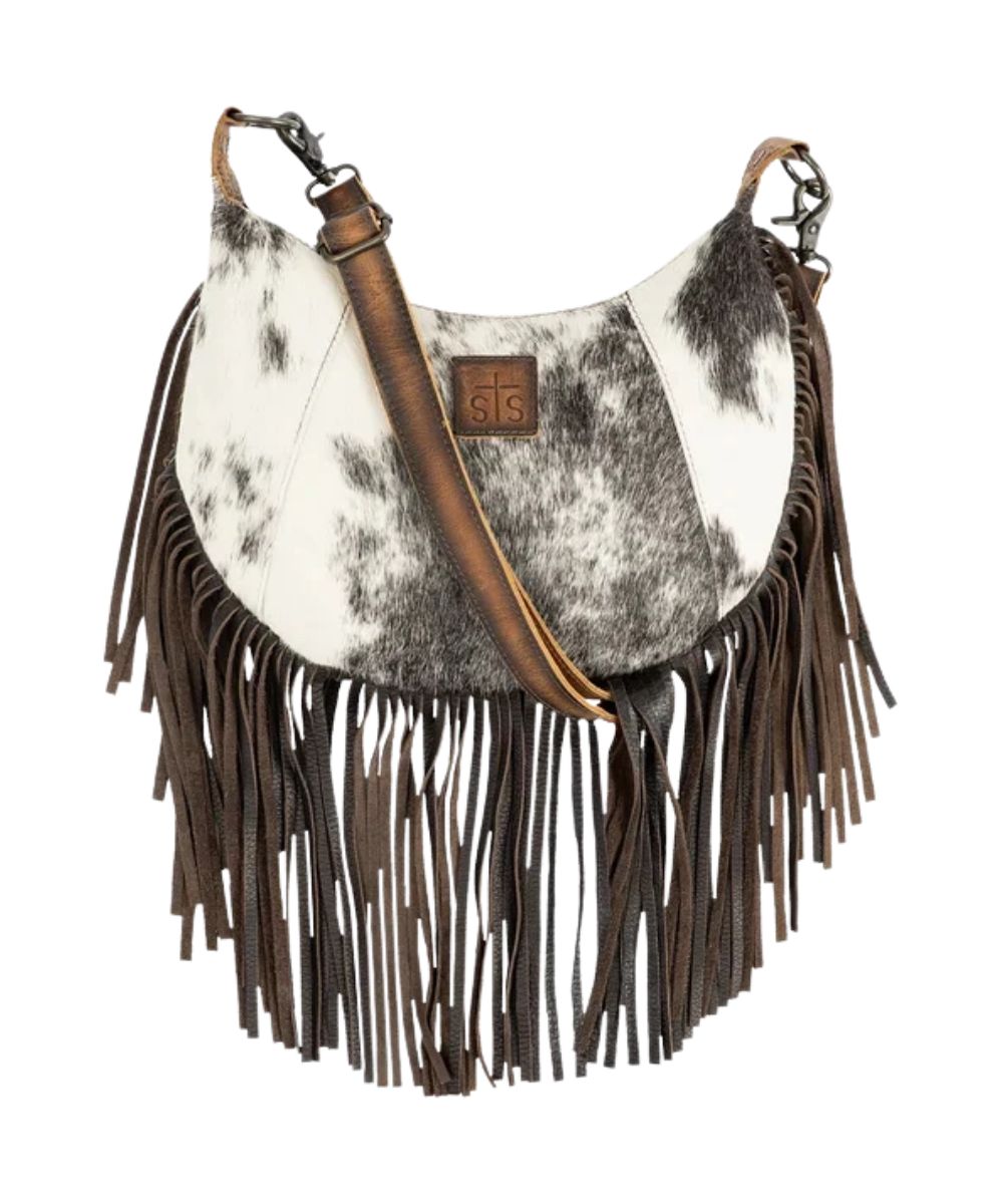 Front view of the women's brown STS Guadalupe Cowhide Nelly Crossbody featuring the hair-on-hide front with a STS branded leather patch, fringe, and a removable/adjustable leather crossbody strap