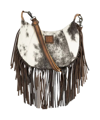 Front view of the women's brown STS Guadalupe Cowhide Nelly Crossbody featuring the hair-on-hide front with a STS branded leather patch, fringe, and a removable/adjustable leather crossbody strap