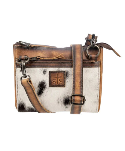 Front view of the women's brown STS Guadalupe Cowhide Lily Crossbody featuring the hair-on-hide front, front zipper pocket, zipper closure on main compartment, and a removable/adjustable leather crossbody strap