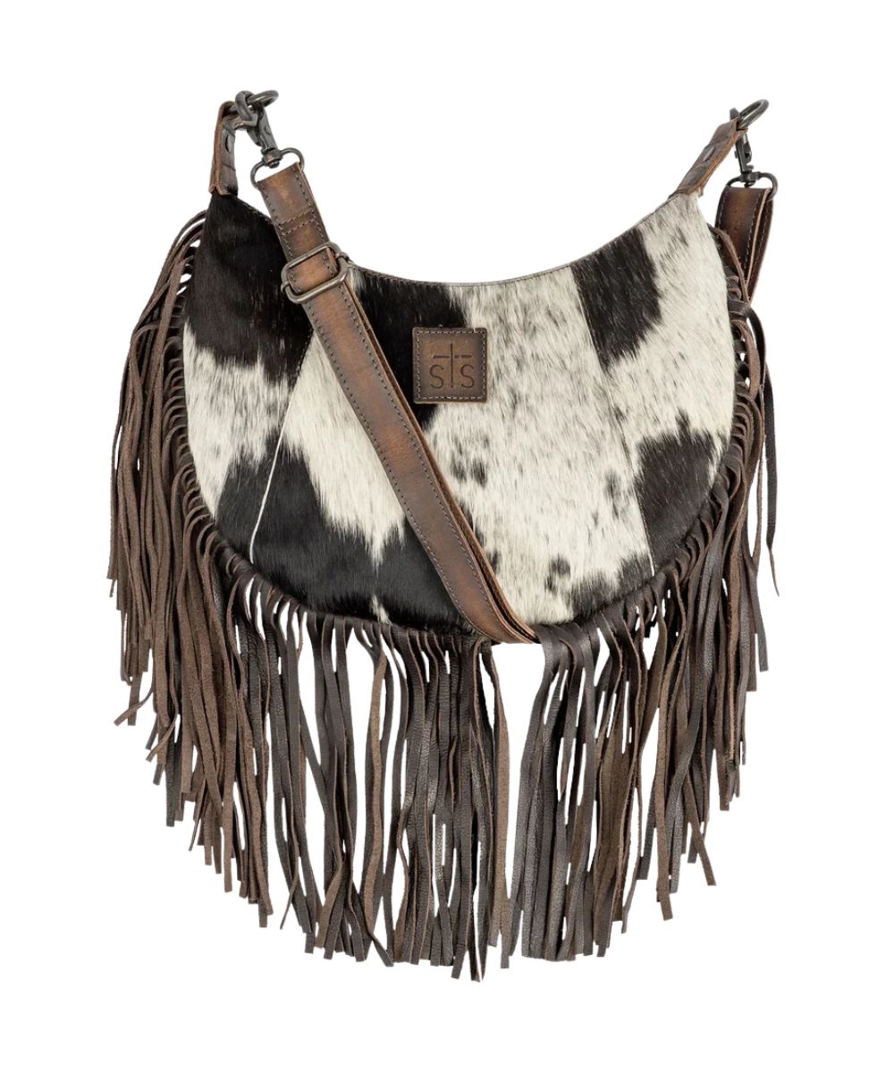 Front view of the women's dark brown STS Cowhide Nelly Crossbody featuring the hair-on-hide leather front, STS branded leather patch, fringe, and a removable/adjustable crossbody strap