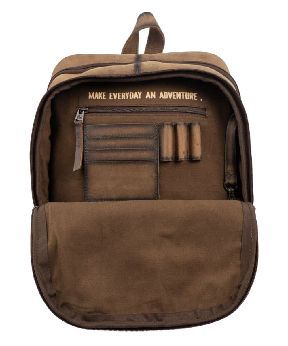 Interior view of the women's cowhide backpack featuring the interior zip pocket, 3 pen slots, 4 card slots, inside quote that reads: "Make Everyday An Adventure." and a keychain clasp