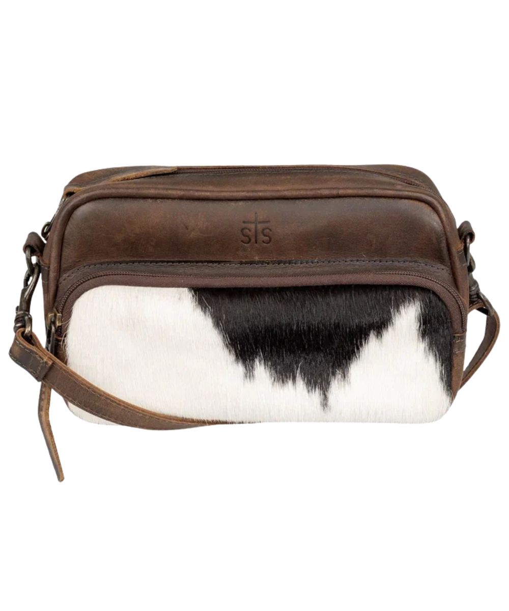 Front view of the women's dark brown STS Cowhide Jess Crossbody featuring the hair-on-hide front zipper pouch, STS stamped leather, top-zipper closure, and a removable/adjustable crossbody strap