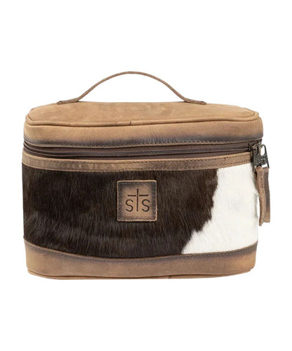 Front view of the women's brown STS cowhide leather train case featuring the logo patch, top carry handle, and zip-around closure