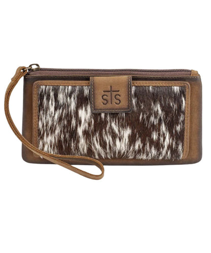 A cowhide leather wristlet wallet with brown leather trim, a top zipper, and a wrist strap featuring an embossed 'sts' logo