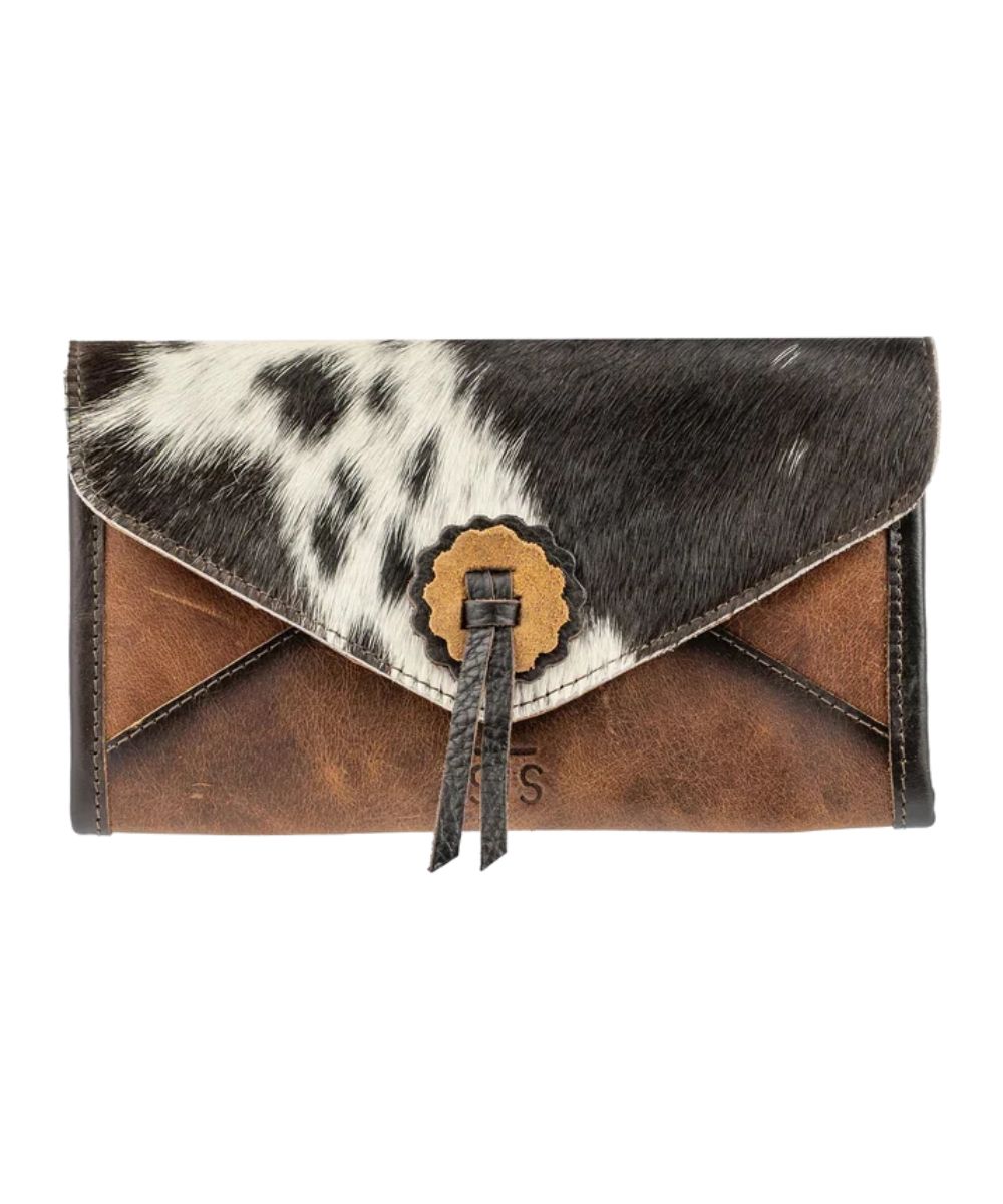 Front view of the women's brown STS Guadalupe Cowhide Style Wallet featuring the magnetic snap flap closure, hair-on-hide flap with leather concho and fringe accents, and STS branded leather