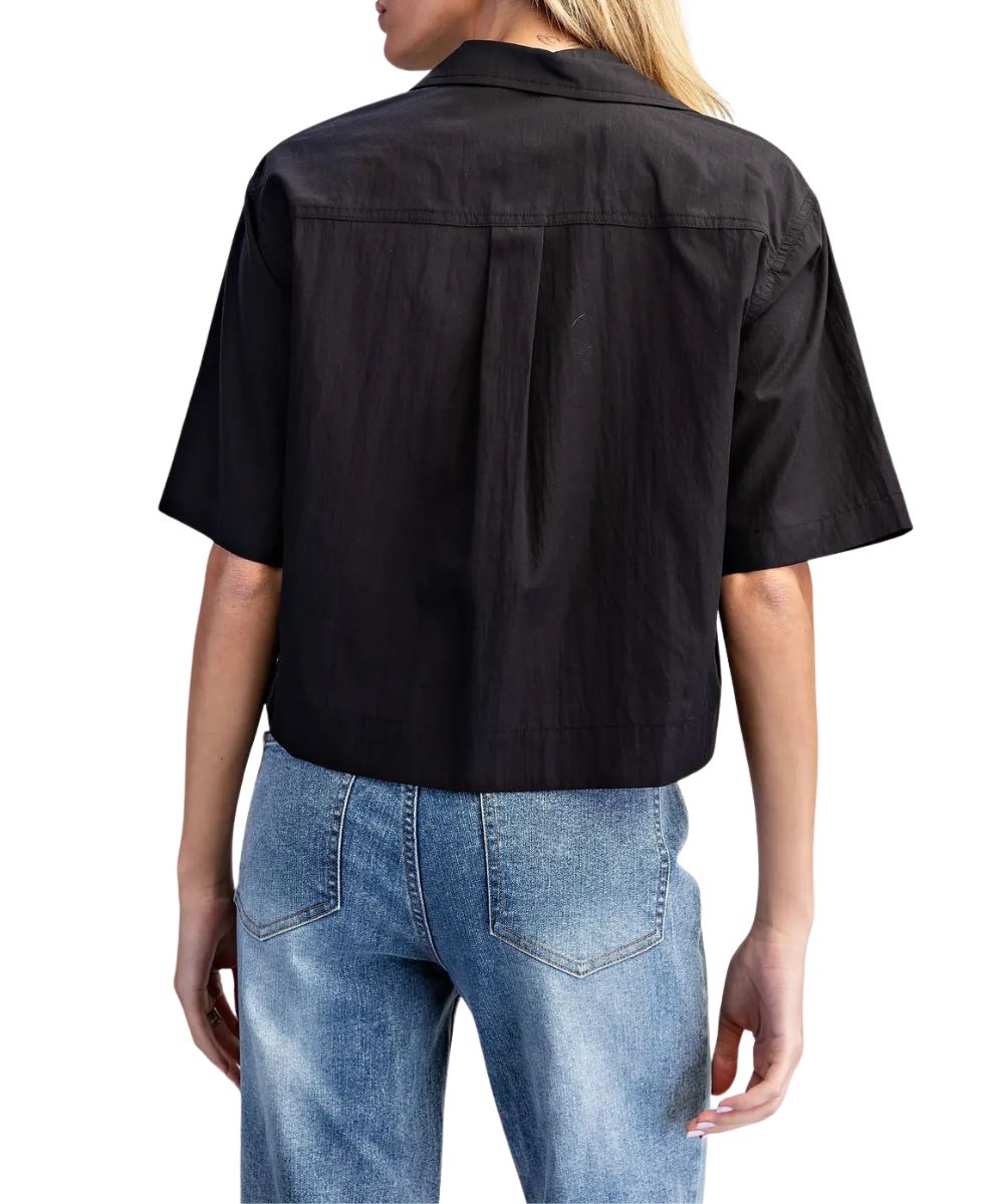 Back view of the women's black short sleeve button down blouse featuring the straight back yoke with a box pleat