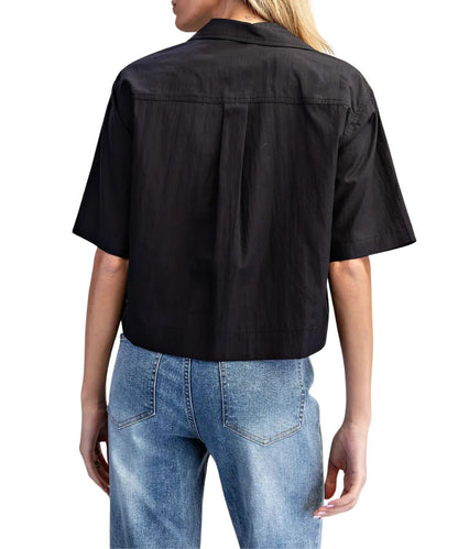 Back view of the women's black short sleeve button down blouse featuring the straight back yoke with a box pleat