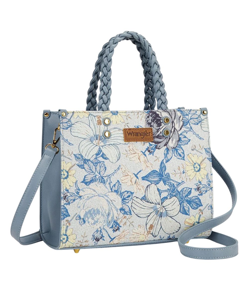 Front view of the women's light blue jean Wrangler Tote Bag featuring the Wrangler logo applique on the front, braided top carry handles, and floral print on white canvas