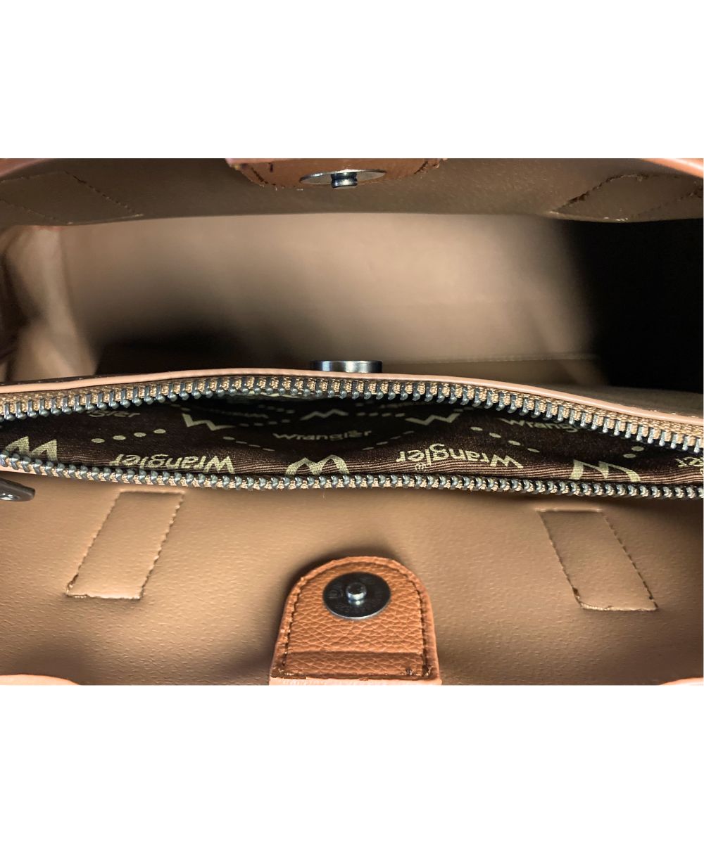 Close-up of the interior of a Wrangler handbag, showing a tan leather interior, silver zipper, and the brand name printed repeatedly on the dark brown zipper tape.