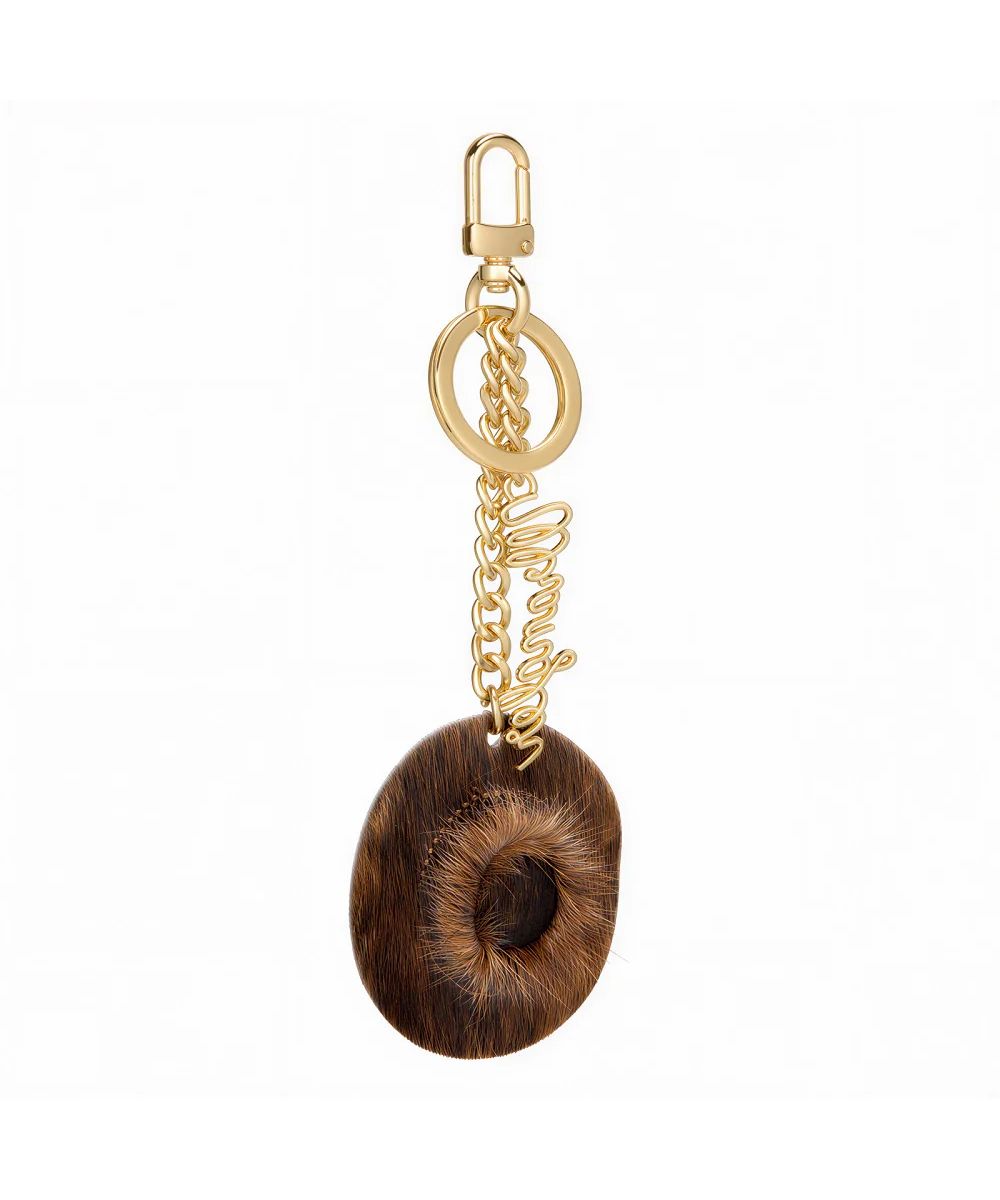 brown and gold purse charm with cowboy hat on white background