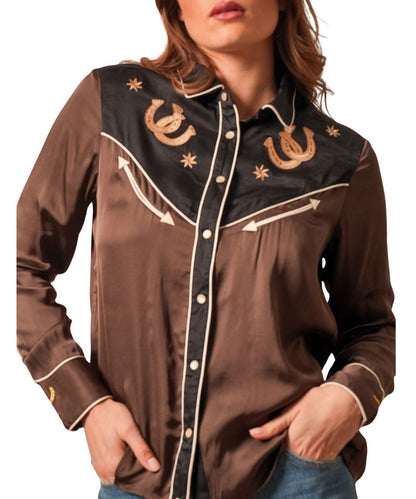 Front view of the women's black Kimes Ranch long sleeve pearl snap shirt featuring the intricate embroidered details at the yokes and cuffs with horseshoes and stars, white pearl snaps, white piping trim, contrasting yokes, placket, and collar