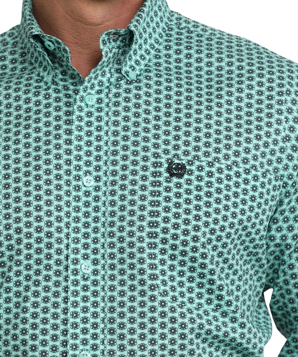 Close up view of single chest pocket and button down collar of the turquoise and black floral print shirt